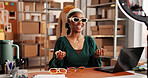 Sunglasses, influencer and promotion with black woman in warehouse for startup, ecommerce and ring light. Content creation, online shopping broadcast and live streaming with person and accessory
