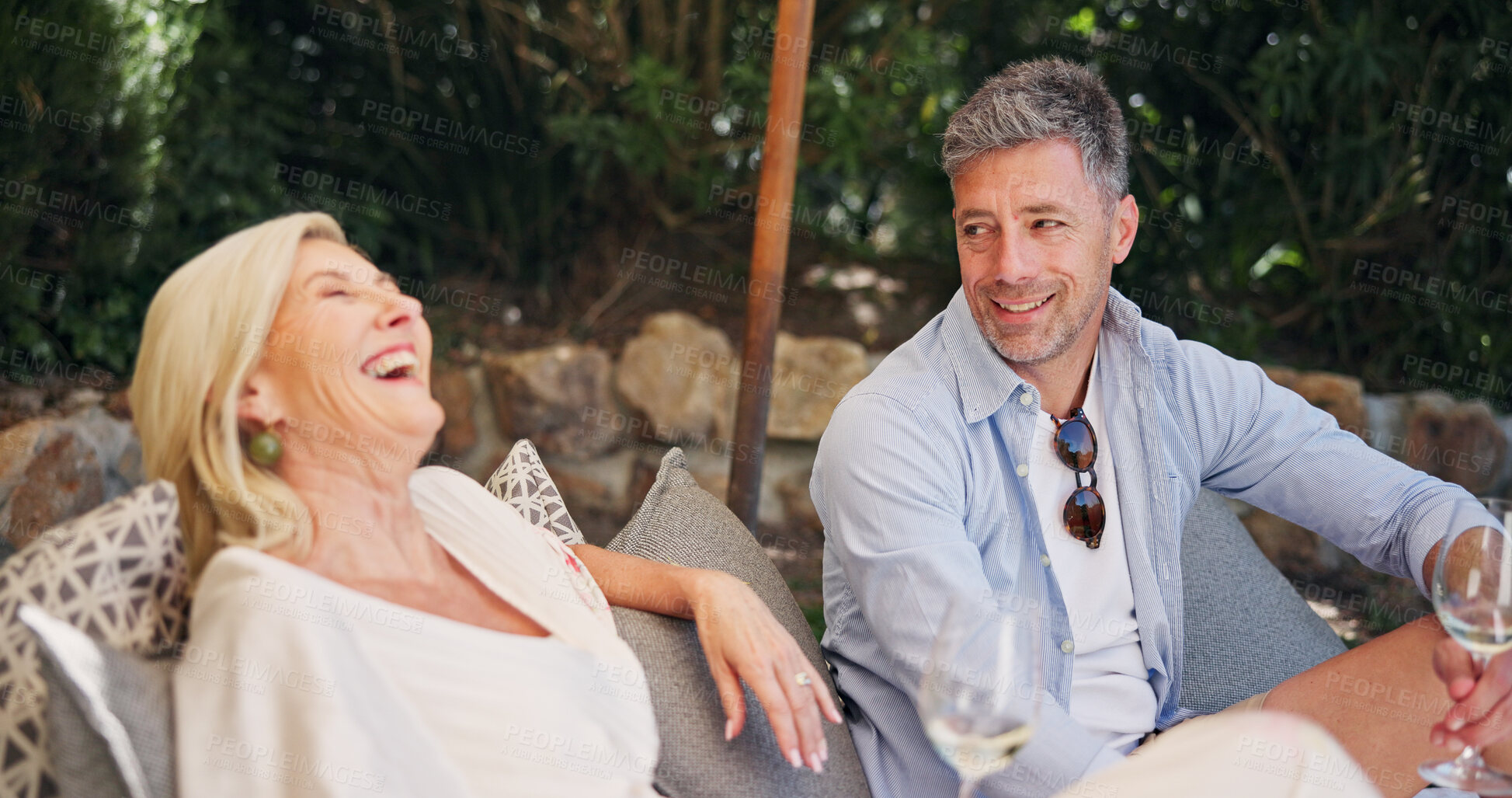 Buy stock photo Relationship, laugh or couple at resort with wine, happy or bonding in anniversary celebration. Honeymoon, love or mature people at lodge with alcohol drink, commitment or connection in romantic date