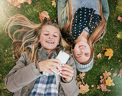 Buy stock photo Phone, typing and smile with friends in park for social media comment, post status update and text message. Communication app, online platform and bonding with above of girl outdoor as teenager