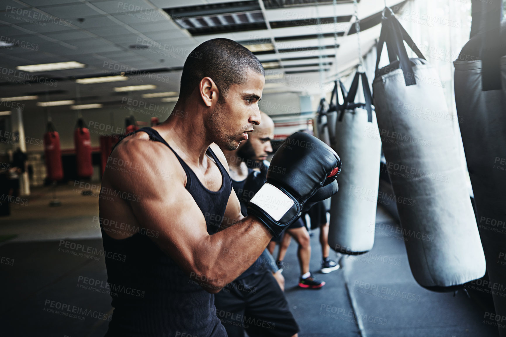 Buy stock photo Boxing class, man and training with punching bag for fight fitness, competition practice or endurance. Gym, pro boxer and workout with people club for conditioning, match preparation and combat sport