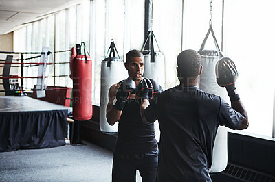 Buy stock photo Athlete, man and boxing with personal trainer at gym for training, punching technique and combat. Male boxer, coach ing or sports mitts for self defense practice, fighting skills and sparring workout