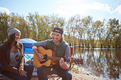 Buy stock photo Couple, camping outdoor and play guitar for love song, date and bonding together on vacation. String instrument, man and woman by tent in nature for romantic music, smile and relax on holiday by lake