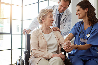 Buy stock photo Doctor, nurse and old person in wheelchair for healthcare, medical consulting or recovery. Conversation, holding hands and rehabilitation of senior woman with disability in hospital for healing