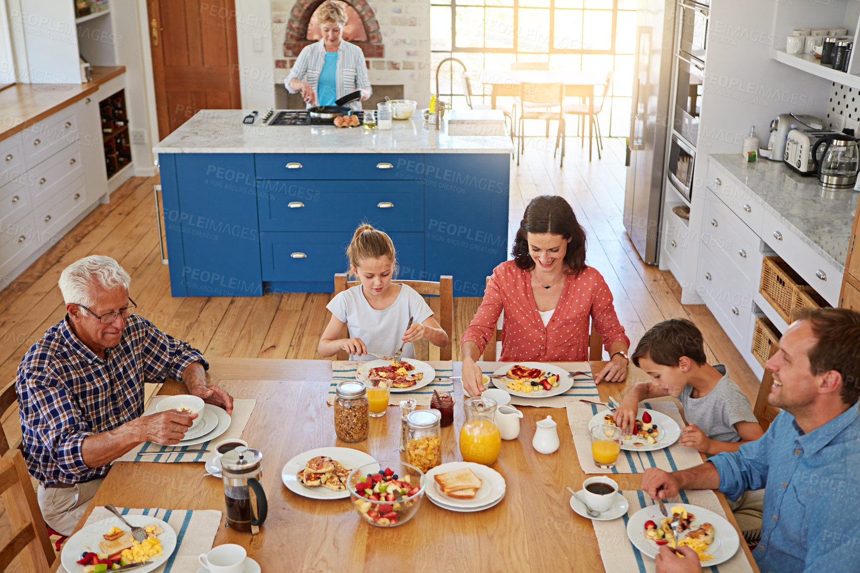 Buy stock photo Happy, eating and family with breakfast in home for bonding, health and nutrition together. Smile, connection and children with grandparents and parents for morning meal with food and juice in house.