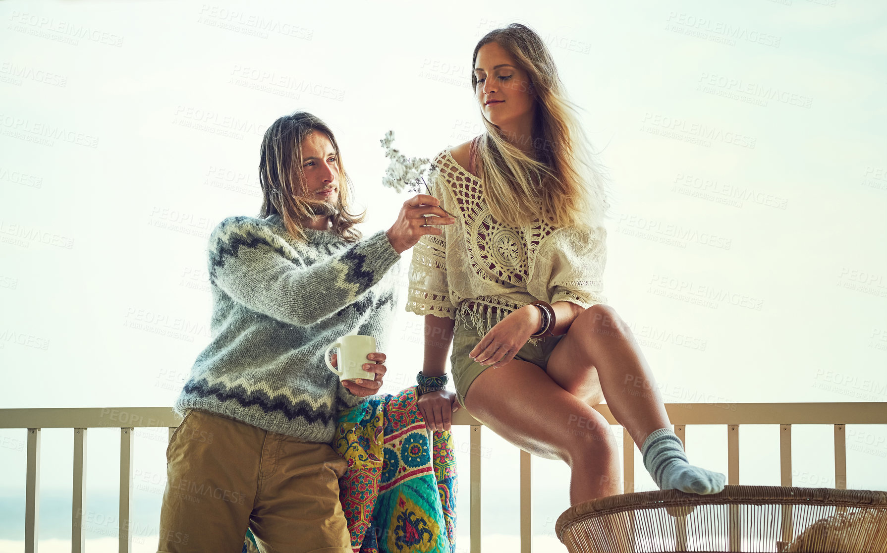 Buy stock photo Couple, relax and flower on balcony outdoor with love, affection and bonding on holiday trip. Space, people and drink on patio with romance, partner admiration and care for getaway vacation at resort