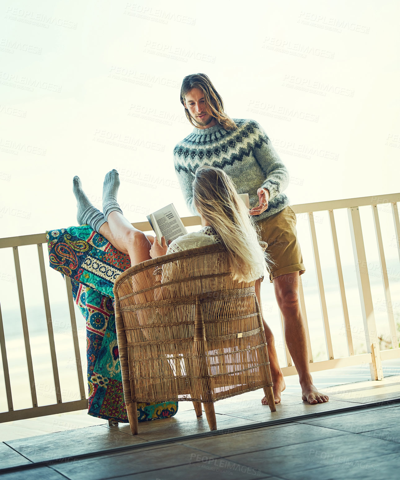 Buy stock photo Book, couple and relax by balcony in home, bonding together or storytelling with conversation. Talk, man and woman with novel in house for hobby, literature or chill with partner with space outdoor