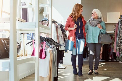 Buy stock photo Senior woman, daughter and walk in boutique for shopping spree, clothing and bonding. Happy, family and elderly mother with outfit selection, collection rack and retail store for customer experience