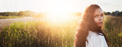 Buy stock photo Sunshine, space and portrait of woman in field for fresh air, holiday and adventure in morning. Countryside, flare and person walking in meadow for tourism, travel and vacation outdoor on banner