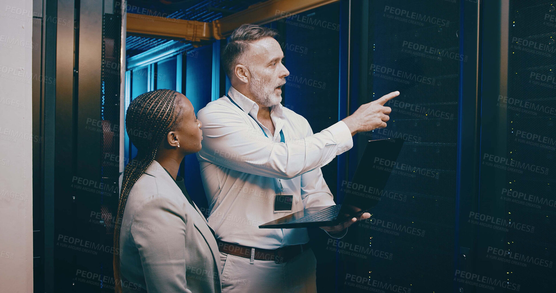 Buy stock photo Laptop, team and people in server room for maintenance, backup or IT training with intern. Collaboration, tech or engineer planning in datacenter, help or manager point at hardware for data storage