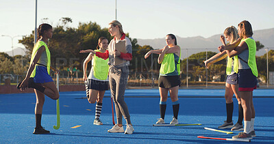 Buy stock photo Women, hockey and players with coach, stretching and game plan with feedback, exercise and wellness. People, outdoor and instructor with athletes, workout and advice with practice, turf and fitness
