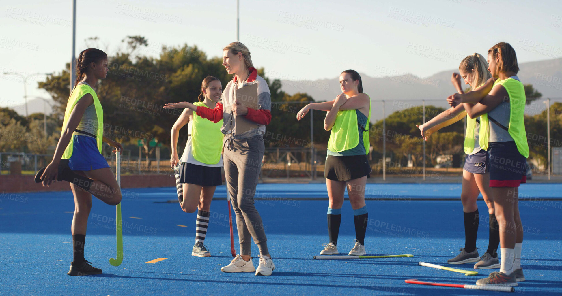 Buy stock photo Women, hockey and players with coach, stretching and game plan with feedback, exercise and wellness. People, outdoor and instructor with athletes, workout and advice with practice, turf and fitness