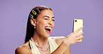 Beauty, selfie and wink with influencer woman in studio for product review on social media. App, haircare and smile of playful content creator isolated on purple background for post or update