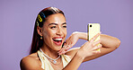 Beauty, energy and selfie with influencer woman in studio for product review on social media. App, haircare and smile of excited content creator isolated on purple background for post or update