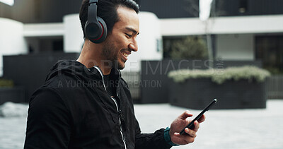 Buy stock photo Exercise, music and phone with man in city for cardio training, running or workout tracking. App, fitness and headphones with athlete or runner typing on mobile for outdoor challenge or sports