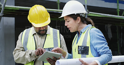 Buy stock photo Woman, man and tablet with inspection at construction site, helmet or discussion for property expansion. People, architect and team with building project, app and blueprint for real estate in city