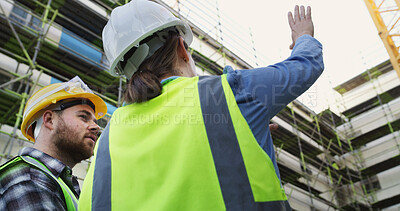 Buy stock photo Construction, planning and back of people in city for building project, infrastructure and meeting. Civil engineering, team and low angle of workers for renovation, property development or inspection