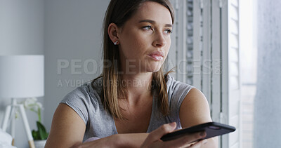 Buy stock photo Woman, phone and sad in bedroom with thinking, notification and online dating chat at apartment. Person with depression, smartphone and bad news on mobile app, contact or post on social media in home