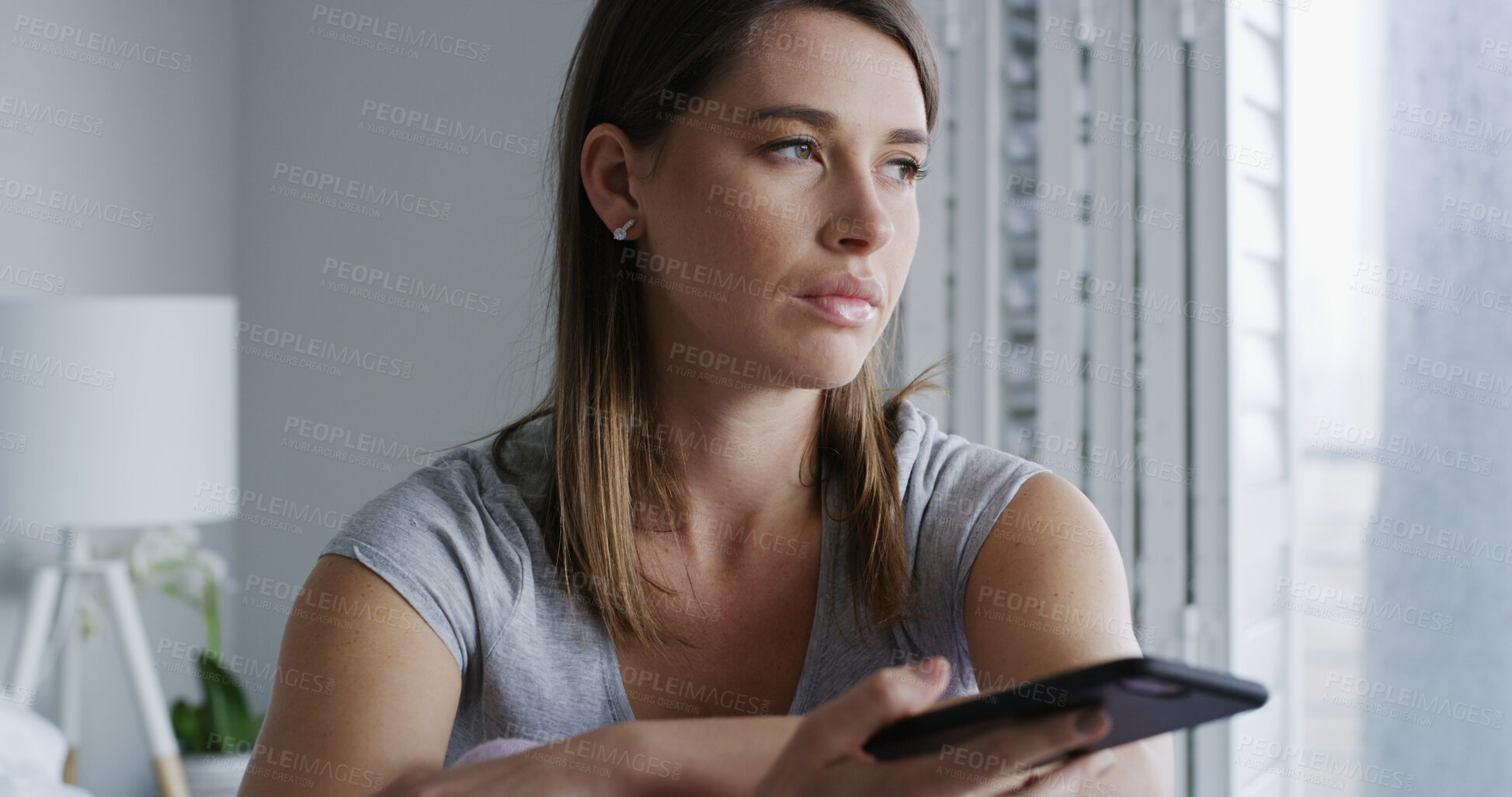 Buy stock photo Woman, phone and sad in bedroom with thinking, notification and online dating chat at apartment. Person with depression, smartphone and bad news on mobile app, contact or post on social media in home