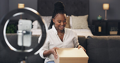 Buy stock photo Content creator, box and black woman in home for recording, unboxing and product review. Influencer, live streaming and person with package, parcel and opening for  online shopping with ring light