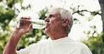 Water, drinking and senior man in nature for relax with fitness, training or exercise in park. Bottle, wellness and elderly male person in retirement with hydration beverage for workout break outdoor
