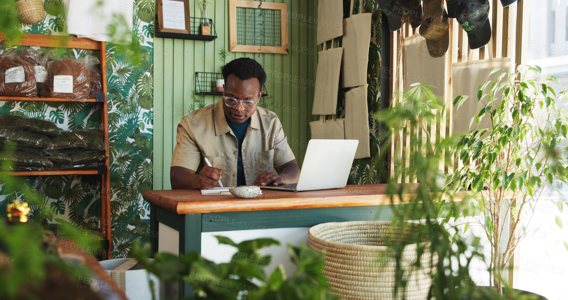 Buy stock photo Laptop, writing and plant with black man in store for delivery checklist, account report and botany review. Order confirmation, ecommerce and florist entrepreneur with person in small business
