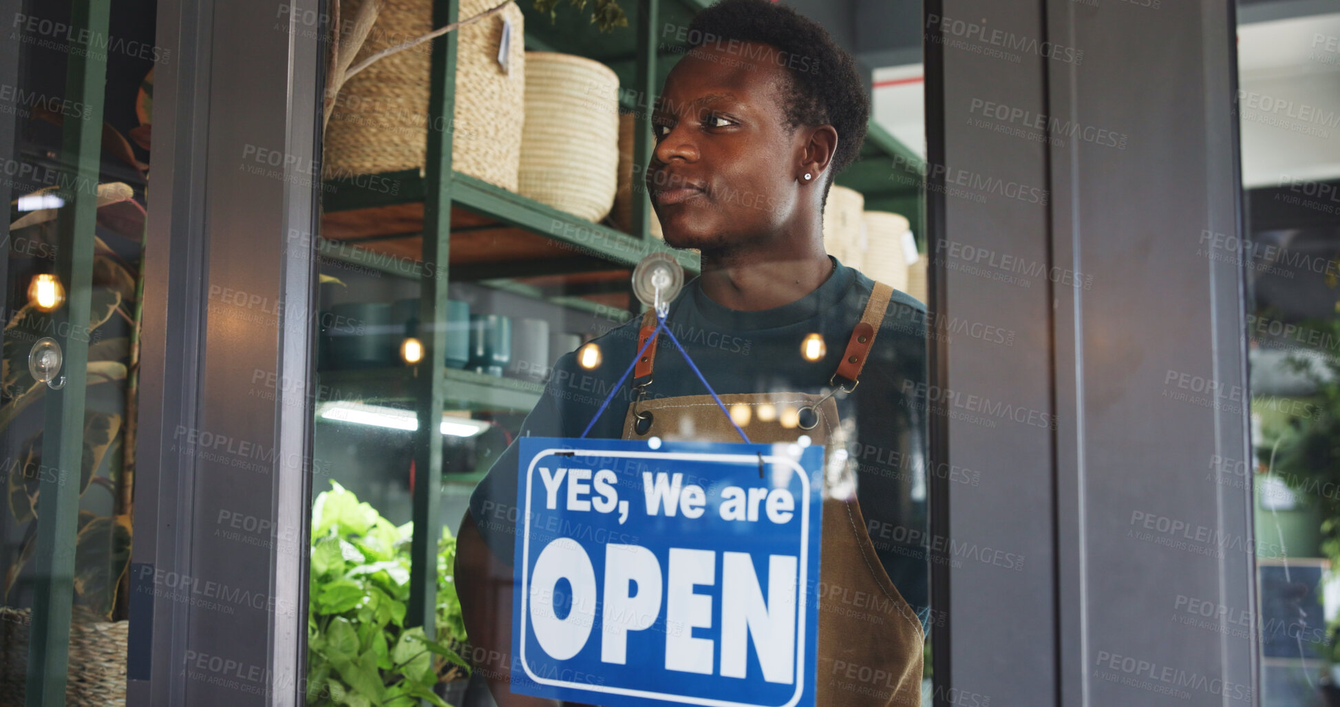 Buy stock photo Black man, open sign and thinking in nursery for sustainable business, botany and eco friendly startup. Botanist, door and board in plant store for operating hours, service announcement and pride