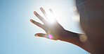 Person, outdoor and hand in sunshine with glare, eye protection and blue sky on holiday. Summer vacation, travel and tourist with shield for UV rays, lens flare and vision safety on nature trip