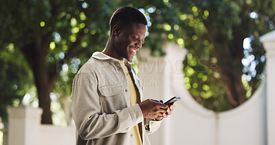 Buy stock photo Black man, walking and smile outdoor with smartphone for communication or social media. Happy male person, typing on mobile phone and contact with texting, message or email in nature with chat app