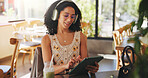 Woman, headphones and tablet in cafe with scroll, audiobook or check online university portal. Student, tech for learning platform or reading with drink or listen to podcast at college cafeteria