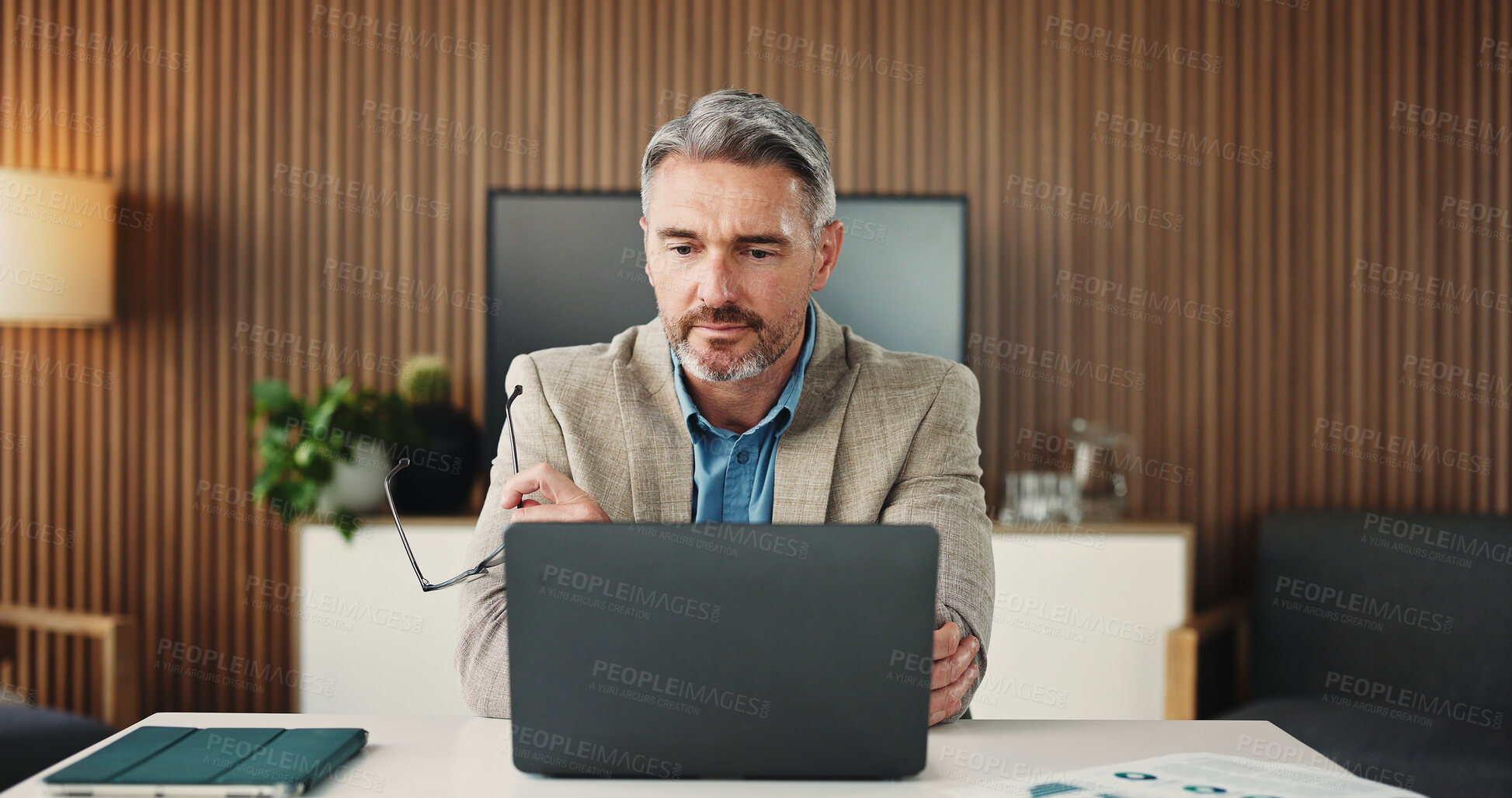 Buy stock photo Man, reading and employee with laptop, office and research for risk assessment on website and online. Business, financial analyst and mature person with tech for budget review and wealth management