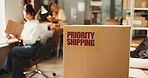 Label, distribution and box in office for cargo with priority shipping for freight delivery. Sticker, cardboard package and ecommerce parcel with express service for logistics, supply chain or export
