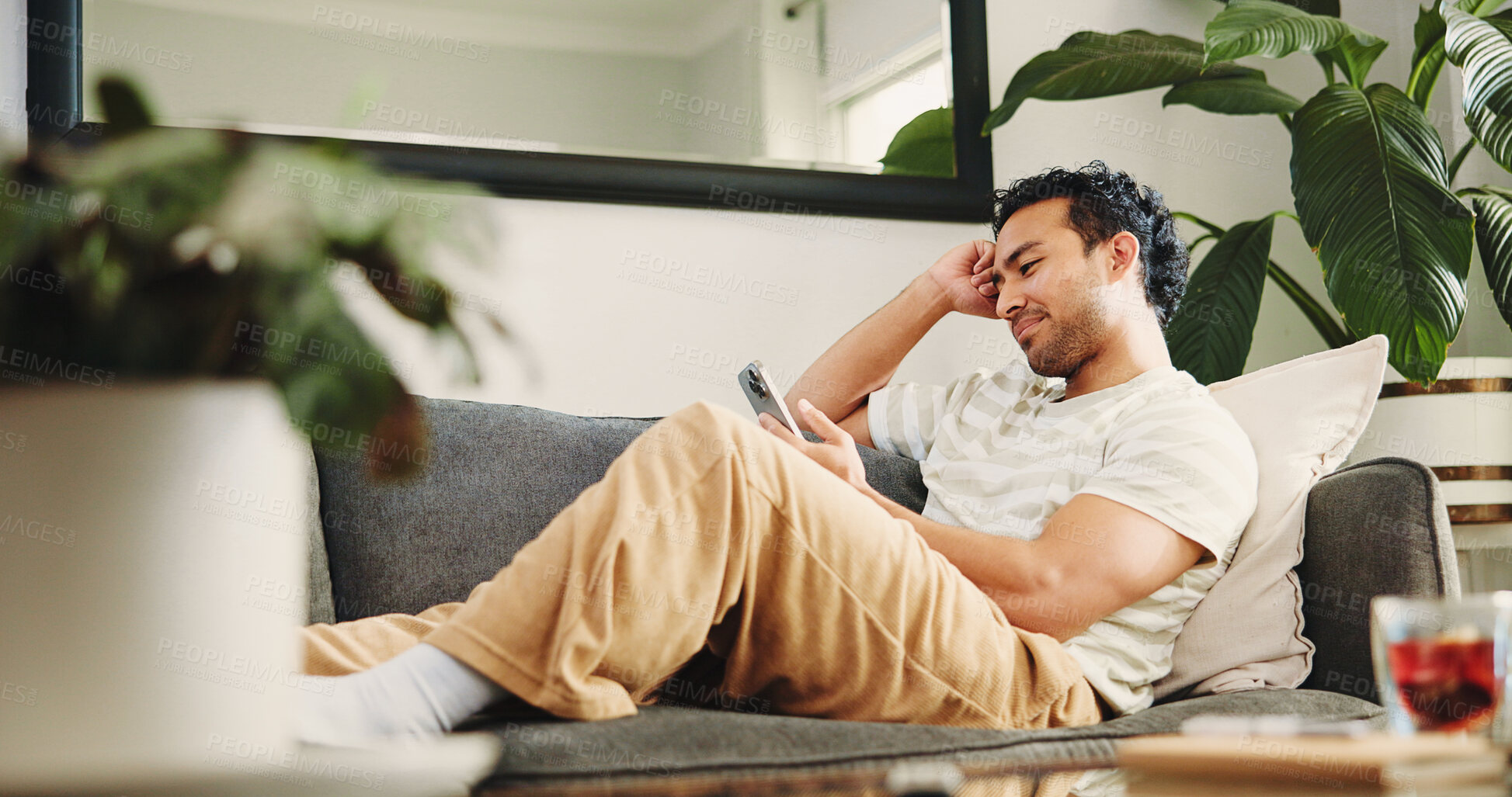 Buy stock photo Home, relax and man on sofa, smartphone and texting with social media, internet or connection. Apartment, mobile user or Asian person on couch, cellphone or network with digital app for communication