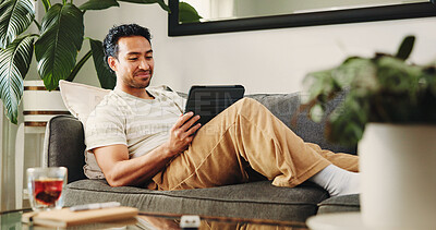 Buy stock photo Man, tablet and smile on sofa, relax and streaming service for movies in living room at home. Person, tech and happy with application, video and film subscription on web, couch or scroll at apartment