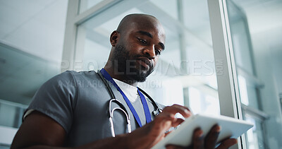 Buy stock photo Black man, doctor and reading with tablet in hospital for research, medical report and test results. Below, male person and digital for healthcare history, treatment planning and surgery schedule