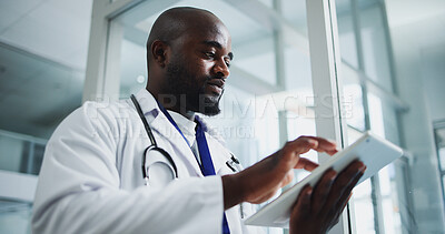 Buy stock photo Black man, doctor and scroll with tablet in hospital for research, medical report and test results. Below, male person and digital with healthcare information, treatment planning and surgery feedback