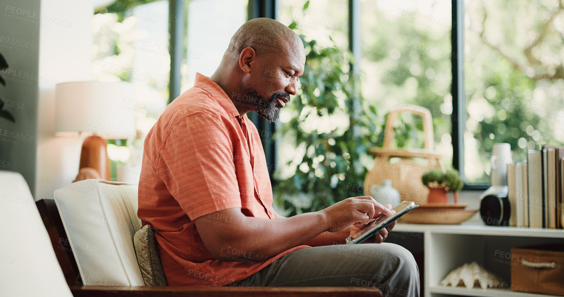 Buy stock photo Living room, reading or black man with tablet in home, internet search or browsing ebook library online. Digital comic, news site or mature person with tech for email app management, novel or blog