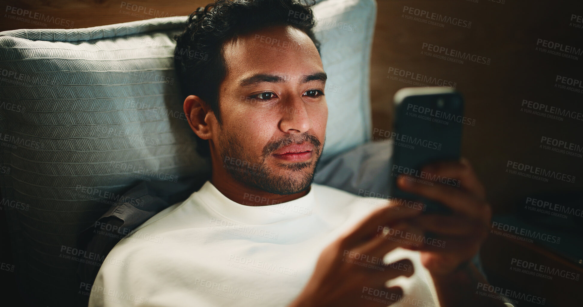 Buy stock photo Night, man and browse in bed with phone for text message reply, social media or check dating app profile. Late, person and scroll with tech in home for online conversation, internet and reading news.