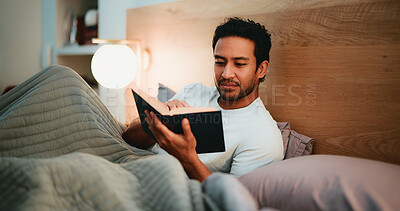 Buy stock photo Reading, book and man in bedroom at night in home with relax for hobby, knowledge or entertainment. Calm, late and male person in bed with fiction story, novel or literature on weekend in apartment.