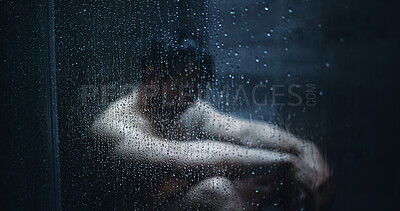 Buy stock photo Man, dark shower and sad by glass in home, stress and mental health with ptsd for bad memory. Person with depression, burnout and anxiety with water drops, window and frustrated in bathroom at house