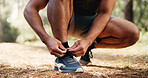 Man, hands and tying with shoes in forest for fitness or workout preparation on hiking trail. Active, male person or runner getting ready with sneaker, tie or laces for trekking safety or exercise