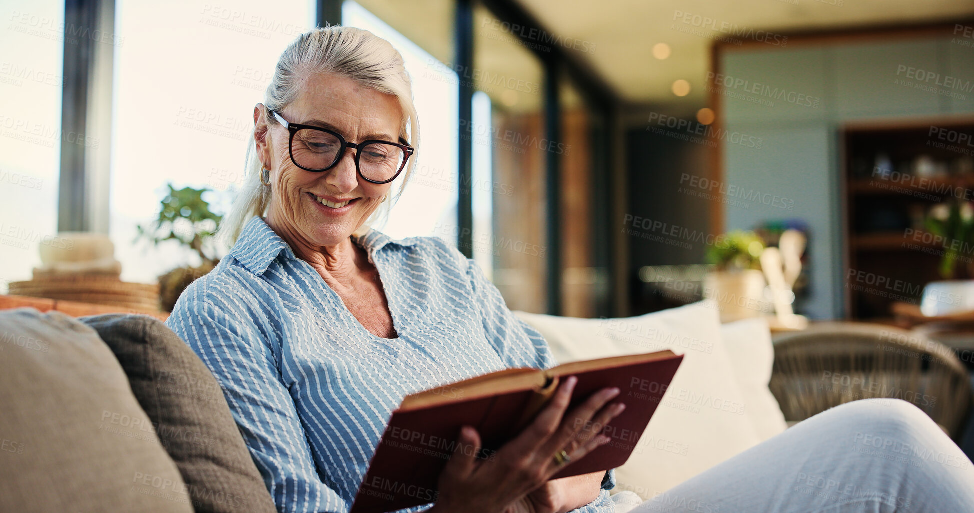 Buy stock photo Reading, book and mature woman on sofa with smile, calm and literature hobby on weekend rest. Free time, space and senior person in house with novel, relax and fantasy story on Sunday afternoon.
