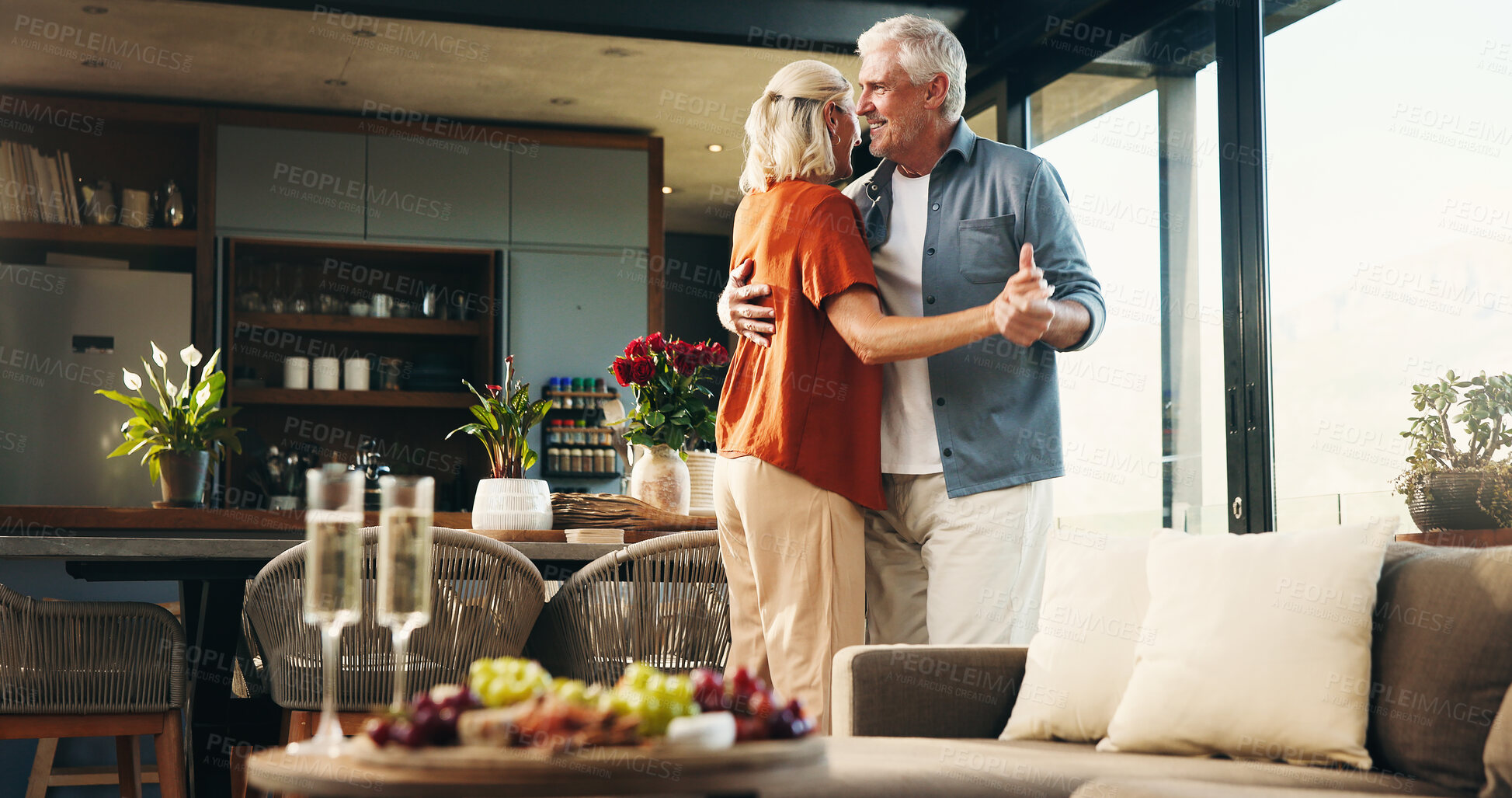 Buy stock photo Charcuterie board, home and old couple with love, dancing and relationship with anniversary. Music, happy man or woman with fruit, champagne and snack platter with celebration, marriage and romance