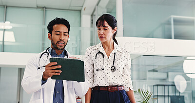 Buy stock photo Doctors, discussion and tablet in lobby with team, review and check schedule for healthcare services at clinic. People, medical staff and tech with app, low angle and walk in hallway at hospital