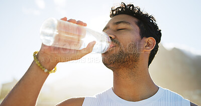 Buy stock photo Below, man and drinking water for fitness outdoor for hydration, nutrition and exercise break. Male person, thirsty and bottle with refreshing beverage, liquid mineral and recovery of cardio training