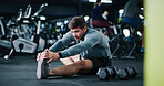 Man, stretching or gym with leg for workout preparation, exercise or indoor training on floor. Active, male person or getting ready with warm up or dumbbells for flexibility or fitness in health club
