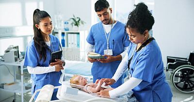 Buy stock photo Hospital, training and nurses with baby doll, healthcare and notes for intern progress and learning. Clinic, health professional and people with fake infant for medical demonstration or knowledge