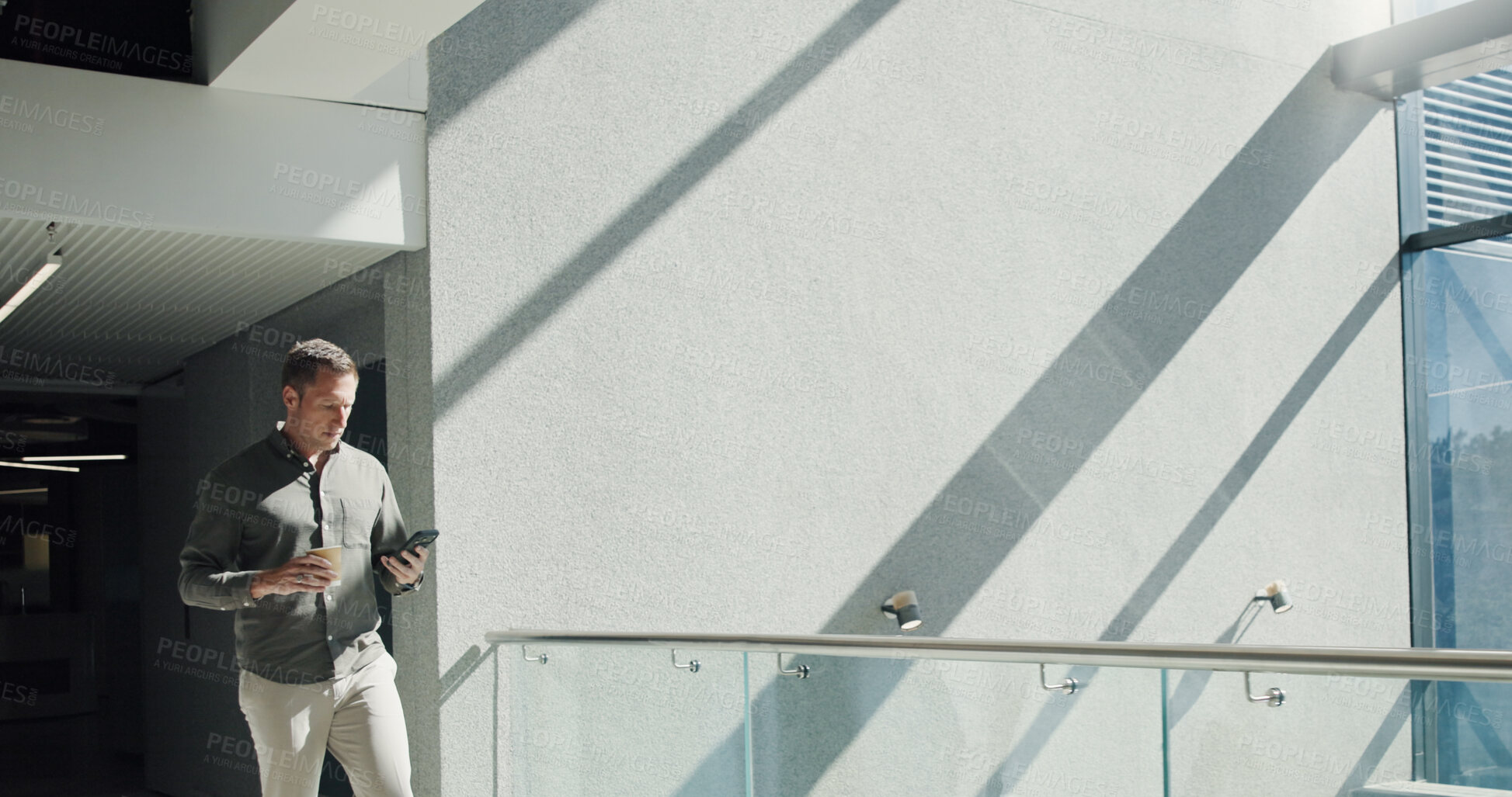 Buy stock photo Businessman, walking and texting with phone in building for social media, research or network. Man, employee or scroll with mobile smartphone, coffee or app for business connection or chat in office