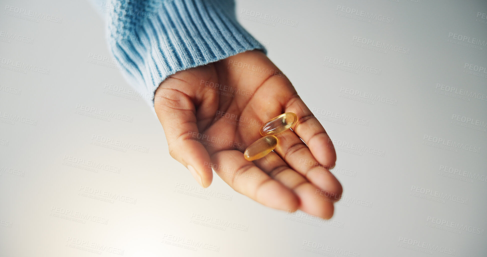 Buy stock photo Hand, pills and person with medicine in studio for health, wellness or sickness recovery. Pharmaceutical, immune booster and model with capsules for vitamins, tablets or medication by gray background