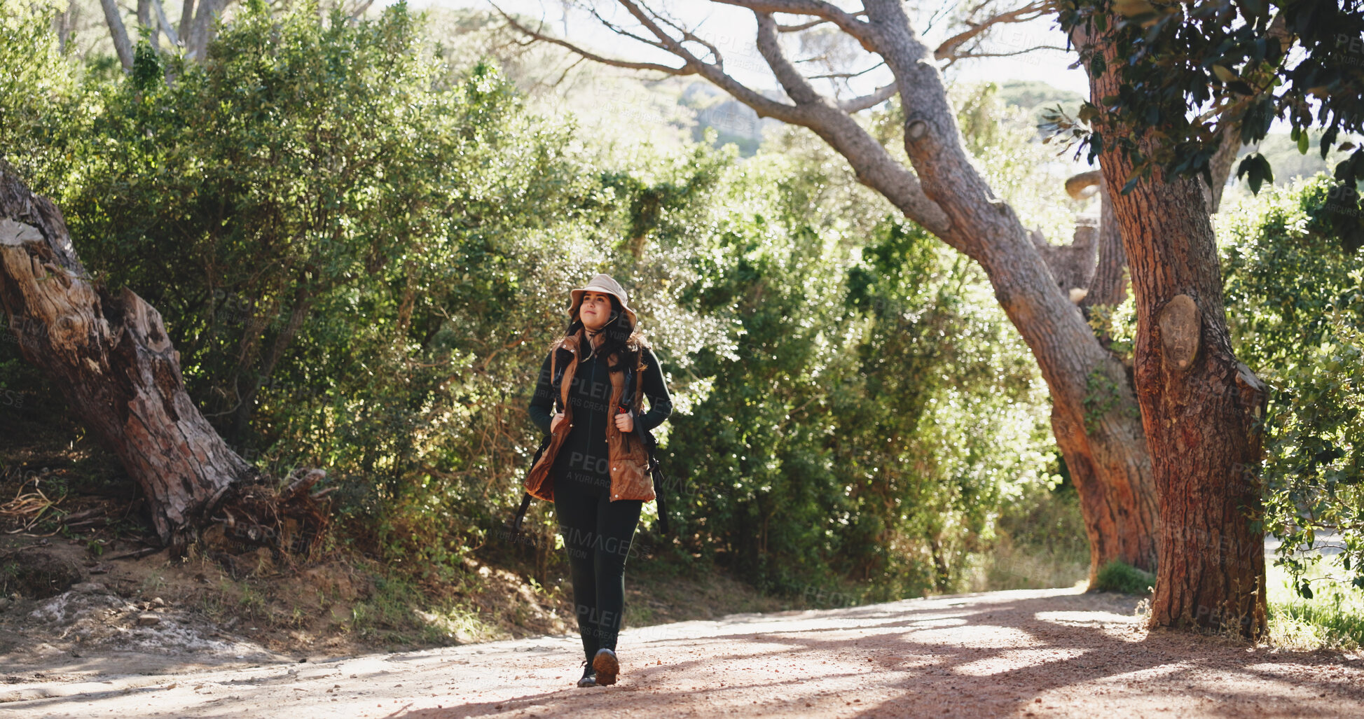 Buy stock photo Thinking, woman and hiking with smile in forest for travel, adventure and sightseeing on holiday. Person, walk and backpacking with reflection, trekking view and explore nature for vacation in woods