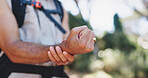 Hands, wrist pain and hiking with injury in forest for adventure with fatigue, tired or carpal tunnel. Person, outdoor and sore joint with stress, inflammation and rest with burnout with trekking